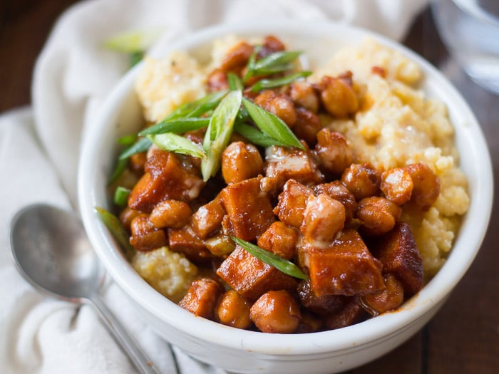 Close Up of a Barbecue Chickpea & Sweet Potato Polenta Bowls Topped with Scallions, Spoon on the Side