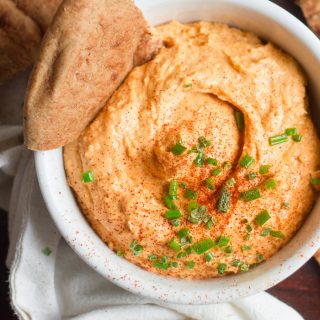 Bowl of Buffalo Hummus Surrounded by Pita Wedges and Topped with Fresh Chives