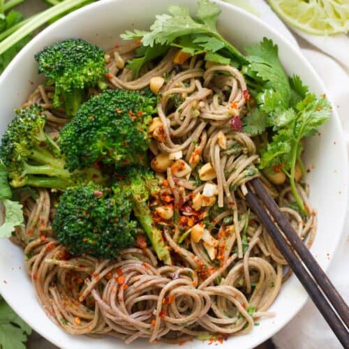 Bowl of soba noodles with peanut sauce and broccoli.