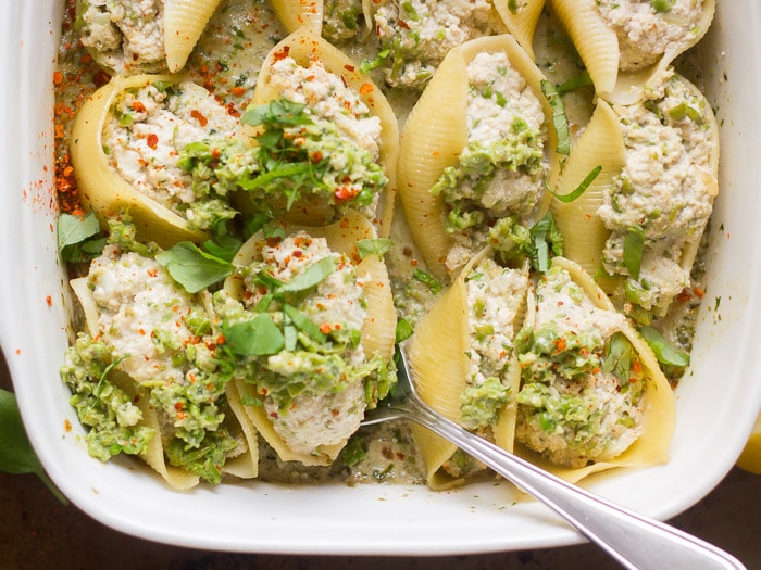 Vegan Pea Pesto Stuffed Shells in a Casserole Dish with Spoon