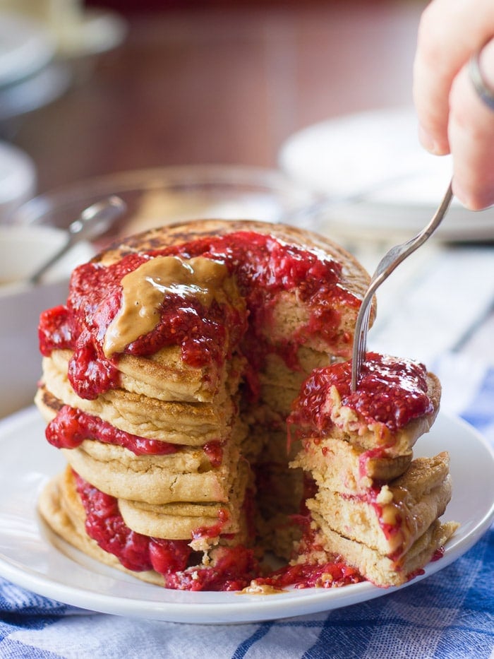 Fork Plunging into a Chunk Cut Out of a Stack of Vegan PB&J Pancakes