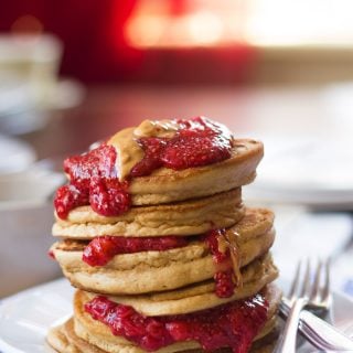 Stack of Vegan PB&J Pancakes on a Plate with Fork and Knife