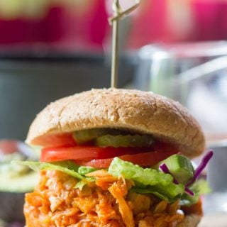Maple Buffalo Pulled Jackfruit Sandwich Topped with Lettuce, Tomato Slices and Pickles