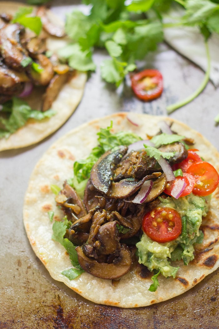 Mushroom Carnitas Tacos with guacamole and cherry tomatoes.