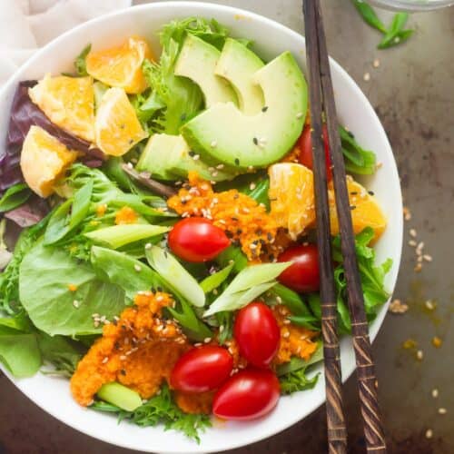 Japanese salad with cherry tomatoes, avocado and carrot dressing.