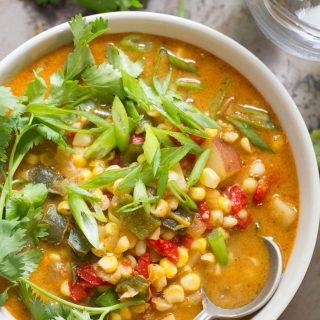 Close Up of a Bowl of Vegan Corn Chowder Topped with Scallions and Cilantro