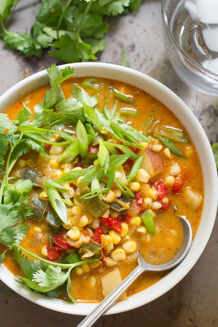 Close Up of a Bowl of Vegan Corn Chowder Topped with Scallions and Cilantro