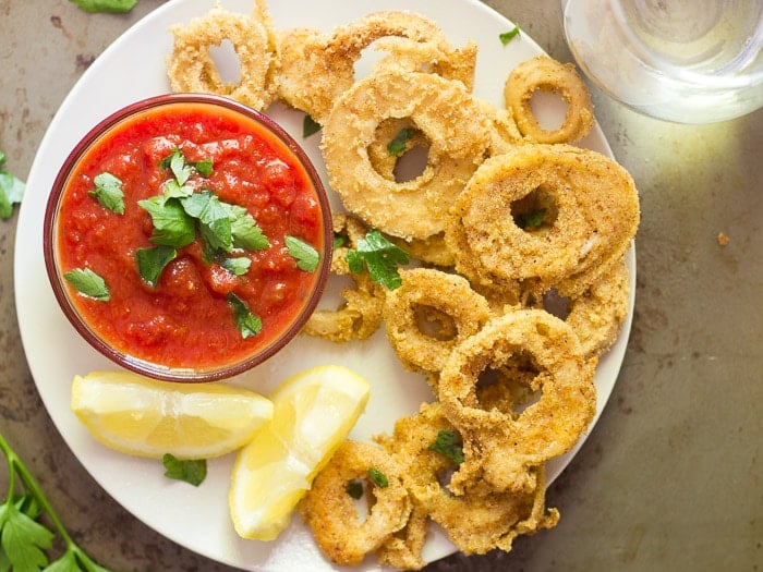 Overhead View of a Plate of Vegan Calamari with Bowl of Tomato Sauce