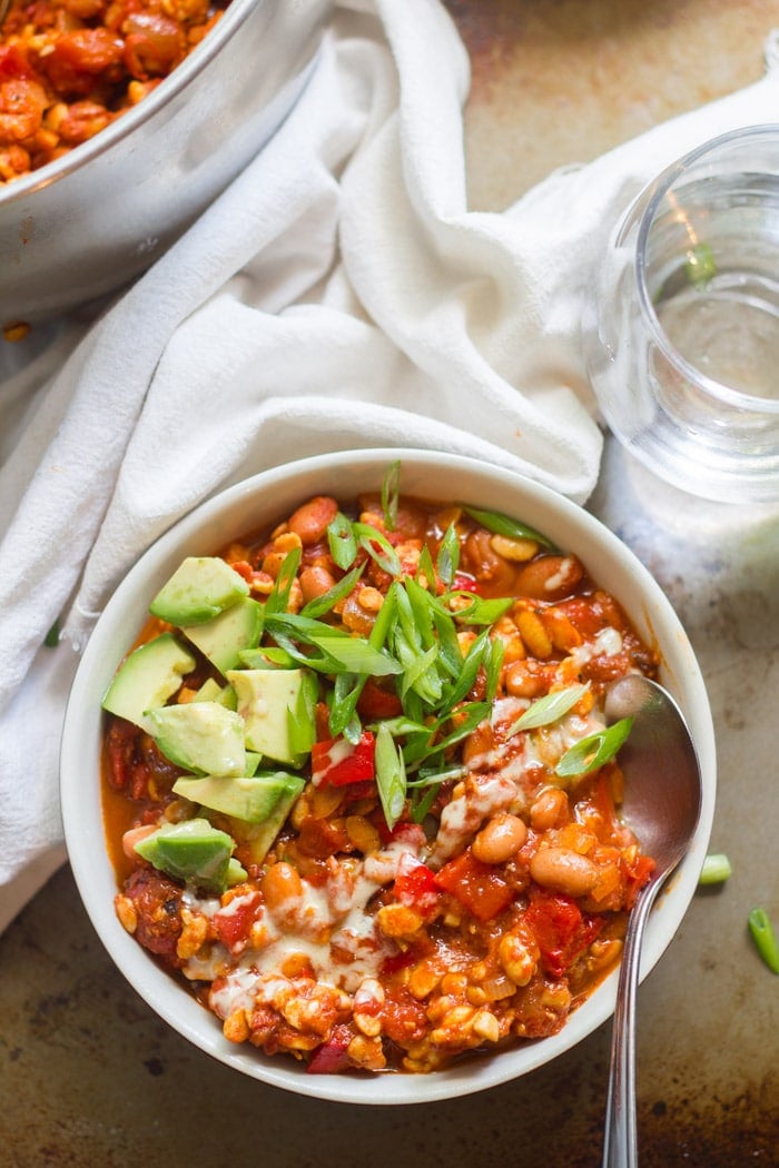 Bowl of Tempeh Chili Topped with Avocado and Scallions