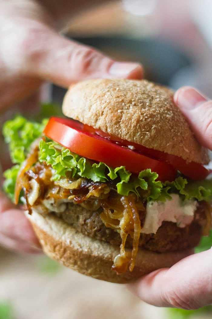 Pair of Hands Holding a Vegan French Onion Burger