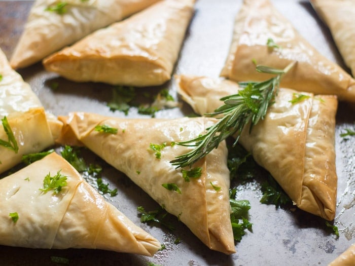 Lentil Mushroom Hand Pies on a Baking Sheet with Fresh Herbs