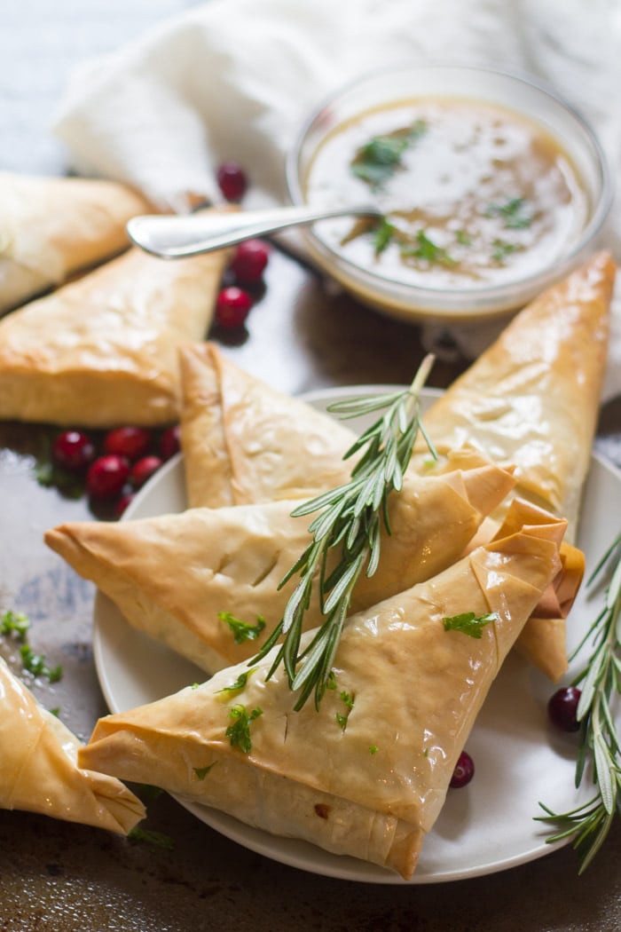 Lentil Mushroom Hand Pies Arranged on a Plate with a Sprig of Fresh Rosemary on Top
