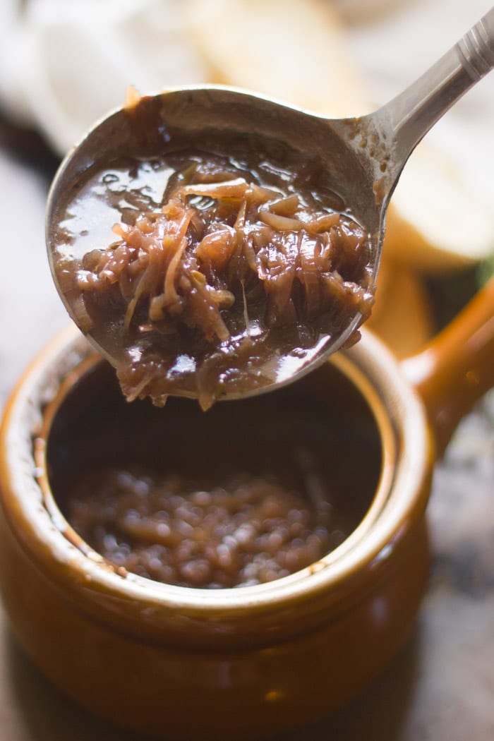 Close Up of a Ladle Filled with Vegan Onion Soup