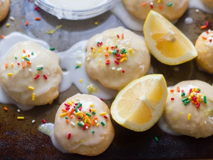 Vegan Lemon Ricotta Cookies and Lemon Wedges on a Baking Sheet