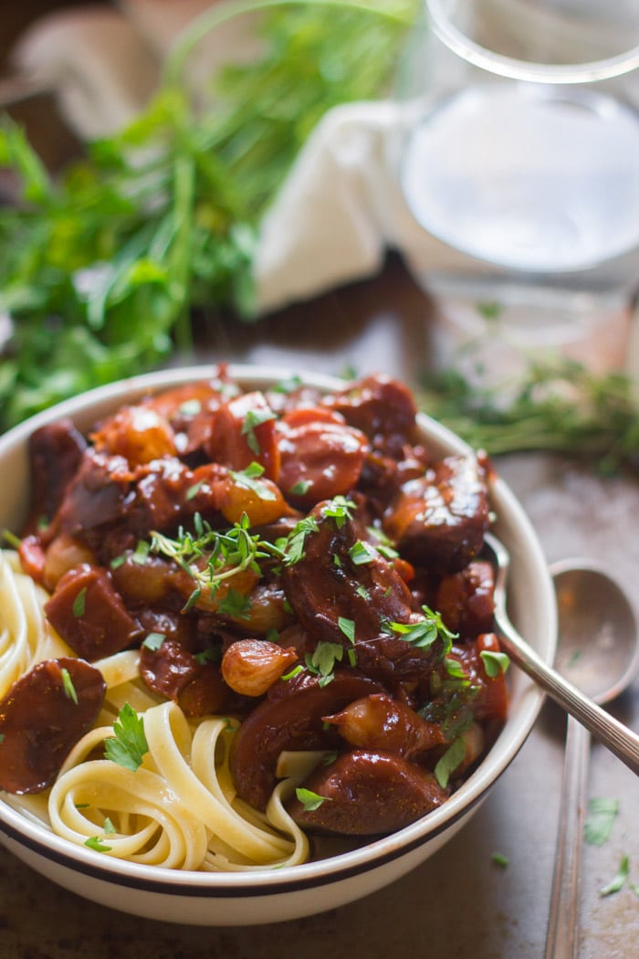 Close Up of Eggplant Bourguignon in a Bowl with Pasta and Fresh Herbs