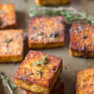 Savory Lemon & Herb Baked Tofu Pieces on a Baking Sheet with Fresh Thyme