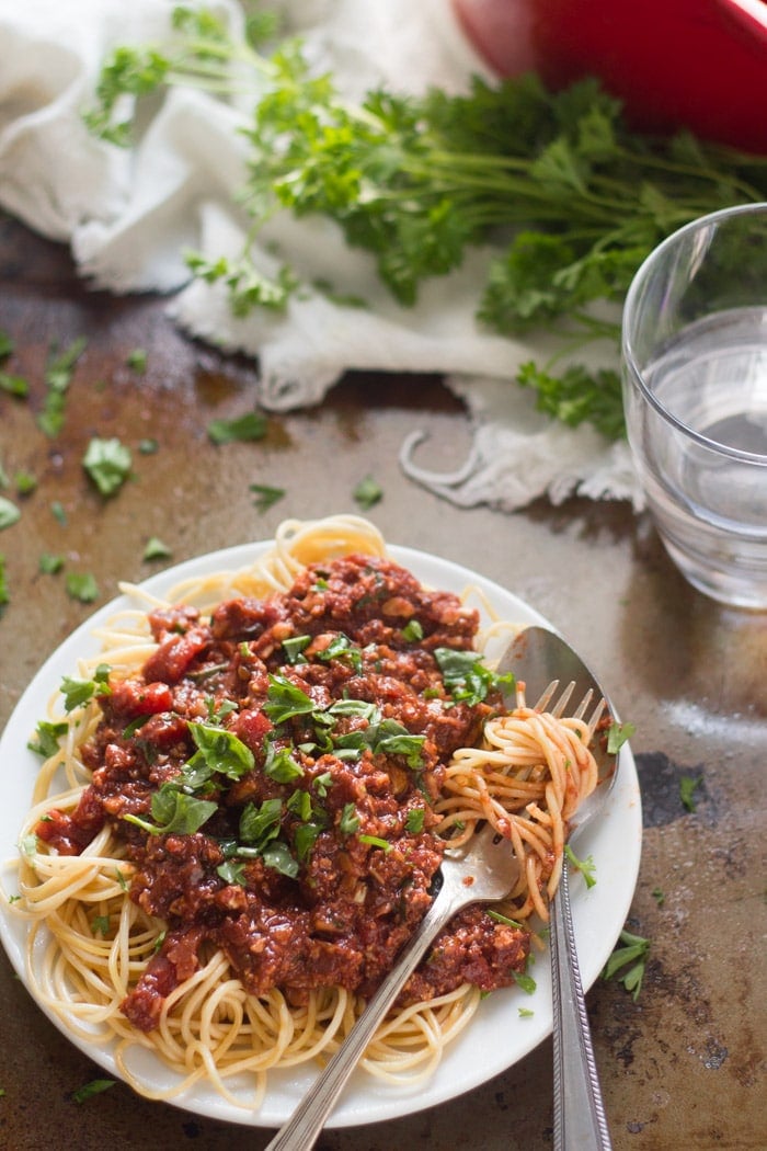 Spaghetti with Cauliflower Walnut Meat Sauce on a Plate with Fork and Spoon