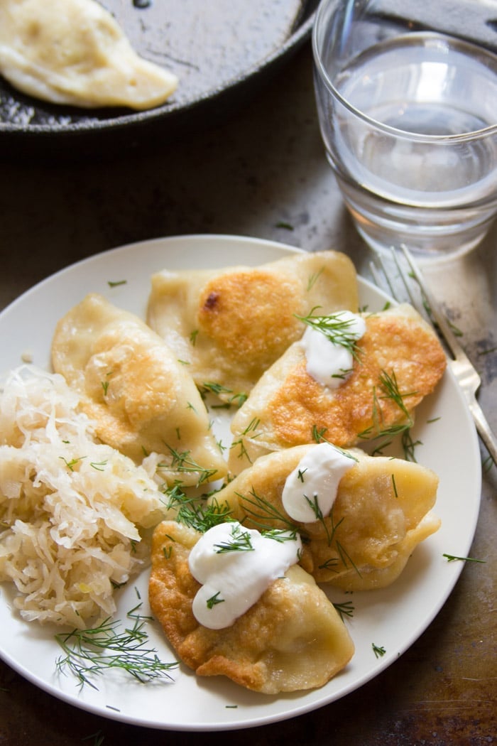 Caramelized Onion & Potato Pierogies on a Plate with Sauerkraut and Dill