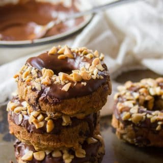 Stack of Banana Doughnuts with a Bowl of Chocolate Peanut Butter Frosting in the Background