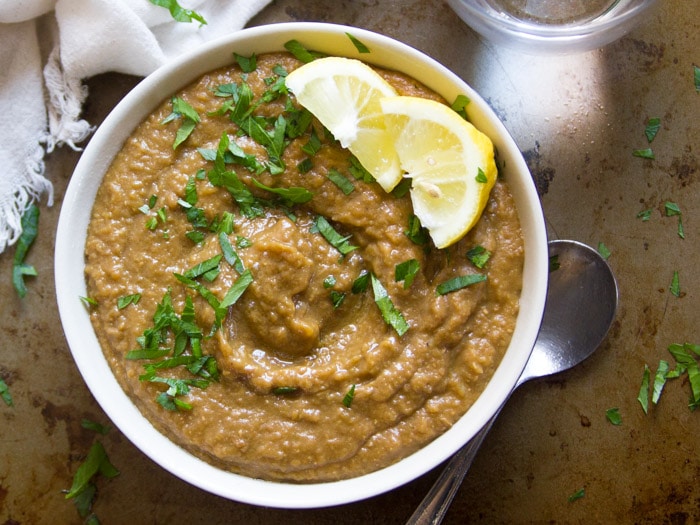 Top View of a Bowl of Warming Spiced Creamy Lentil Soup topped with Parsley and Lemon Slices