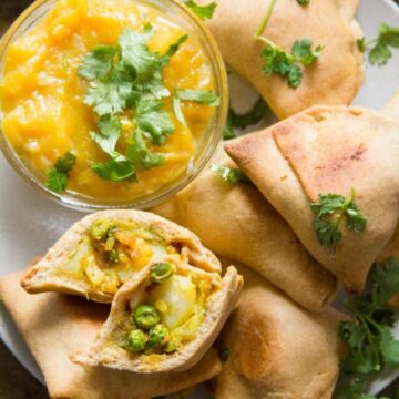 Overhead View of a Plate of Baked Vegan Samosas with a Dish of Mango Chutney