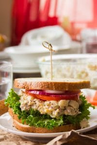 Sándwich de ensalada de atún vegano en un plato con platos en el fondo