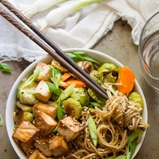Bowl of Sesame Noodles with Roasted Veggies with a Clump of Noodles Wrapped Around a Pair of Chopsticks