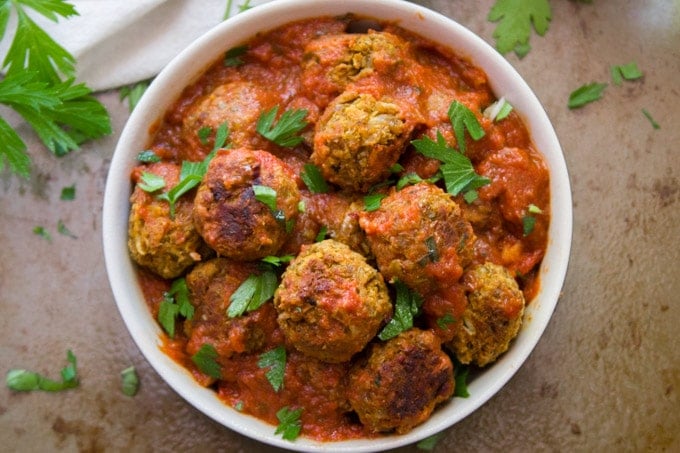 Overhead View of a Bowl of Lentil Meatballs and Tomato Sauce Topped with Parsley