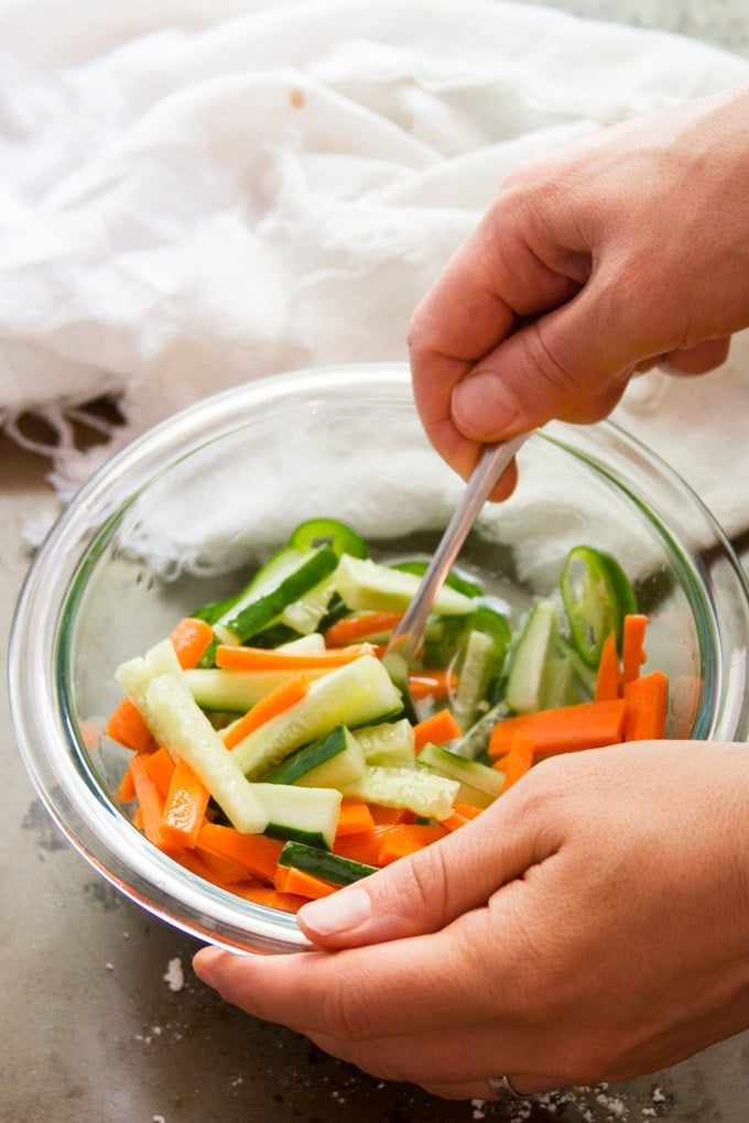Hand Stirring Ingredients For Pickled Veggies Together in a Bowl