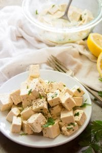 Tofu Feta on a Plate with Fork and Lemon Slices in the Background