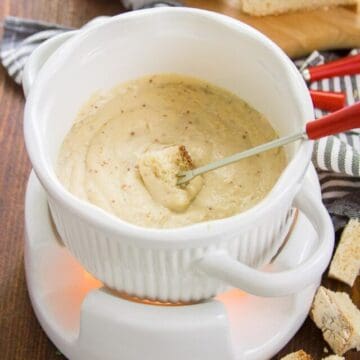 Fork With Bread Cube in a Pot of Vegan Swiss Cheese Fondue