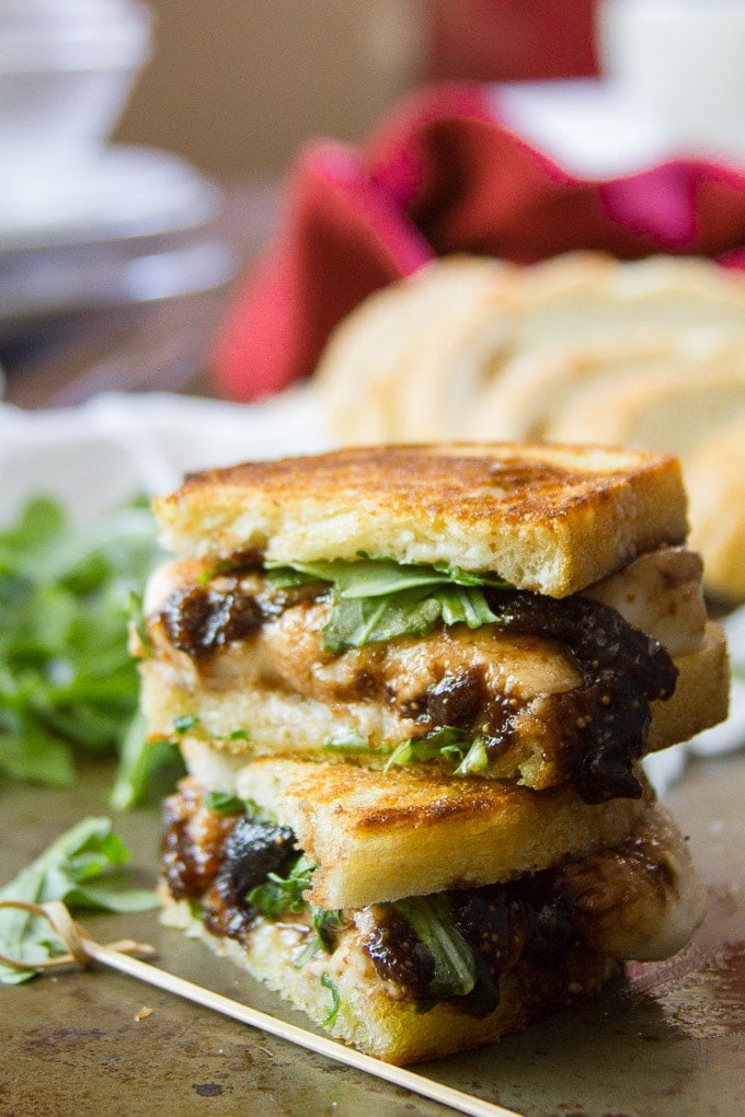 Two Halves of A Vegan Mozzarella & Fig Jam Grilled Cheese Sandwich Stacked on a Plate