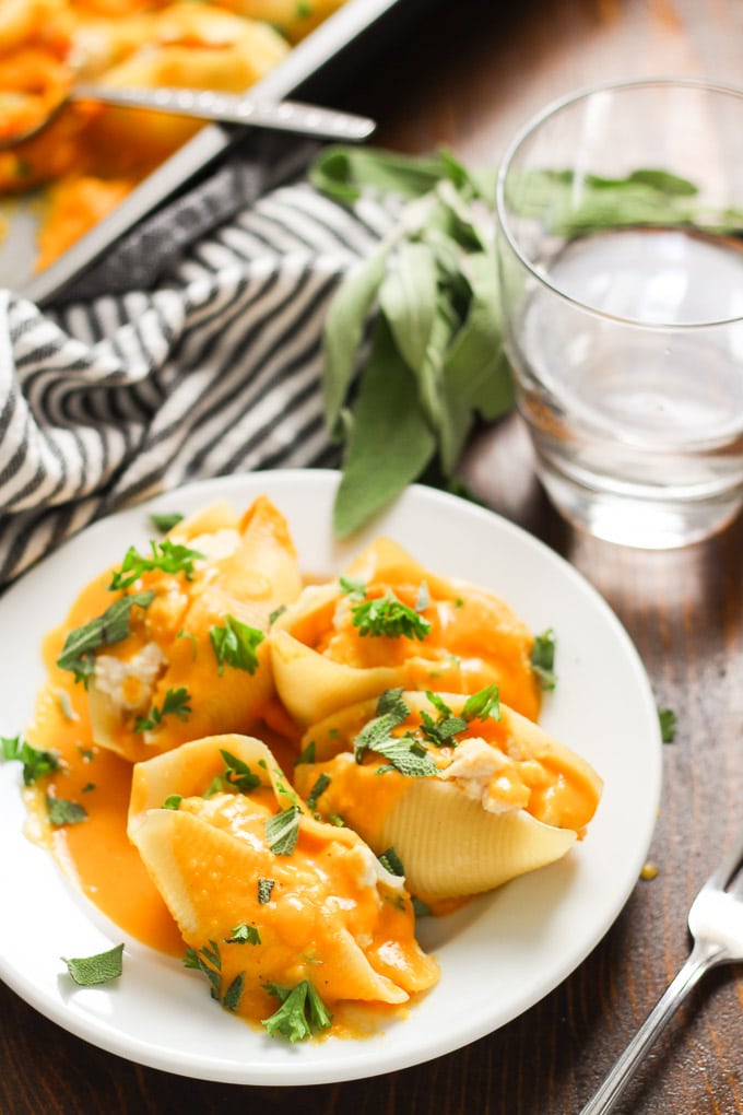 Vegan Butternut Squash Stuffed Shells on a Plate with Fork, Napkin and Drinking Glass