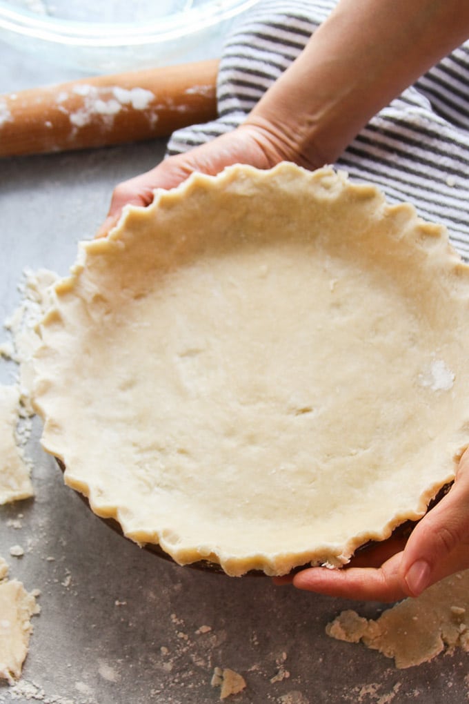 Hands Holding A Newly Made Vegan Pie Crust in a Pie Plate