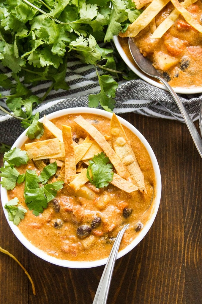 Two Bowls of Vegan Enchilada Soup with Spoons and Napkin