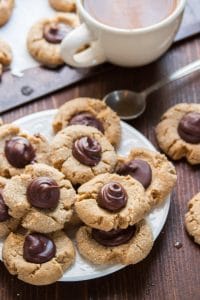 Vegan Peanut Butter Blossoms on a Plate with Coffee Cup and Spoon in the Background