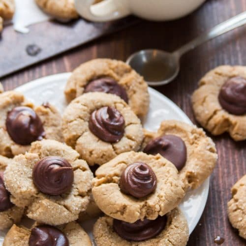 Vegan Peanut Butter Blossoms on a Plate with Coffee Cup and Spoon in the Background