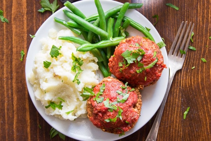 Overhead View of Italian-Style Vegan Meatloaf Muffins on a Plate with Mashed Potatoes and Green Beans