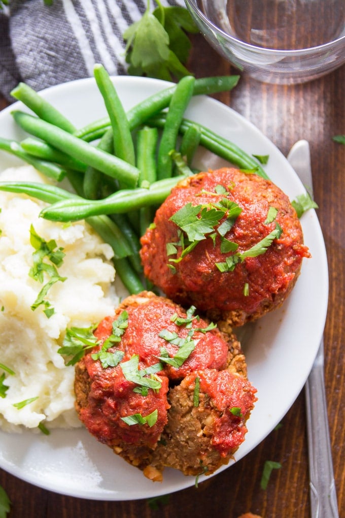 Close Up of Italian-Style Vegan Meatloaf Muffins on a Plate With Mashed Potatoes and Green Beans