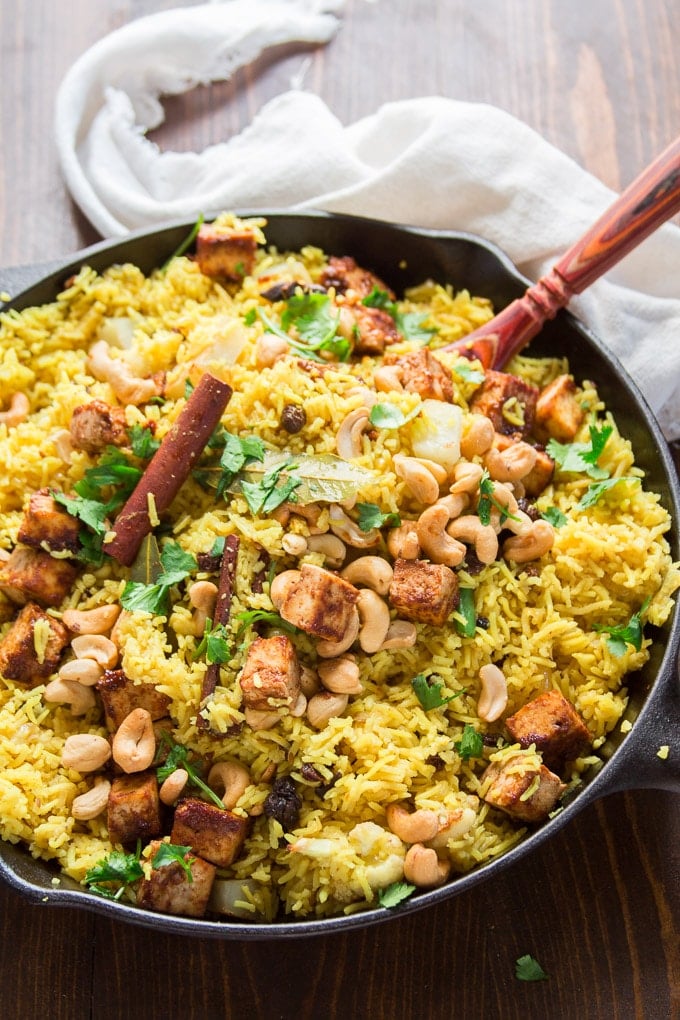Roasted Vegetable Biryani with Baked Tofu in a Skillet with Serving Spoon