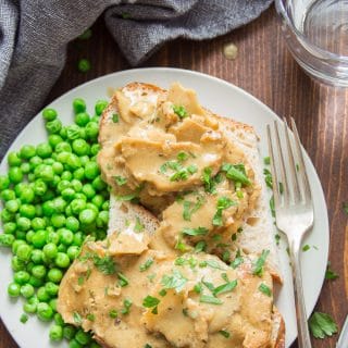 Hot Open-Faced Vegan Turkey & Gravy Sandwich on a Plate with Fork and Water Glass