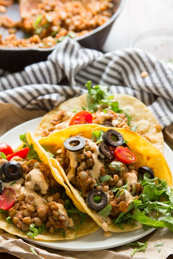Vegan Lentil Tacos on a Plate with Skillet and Napkin in the Background.