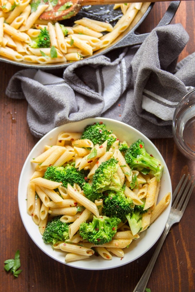 Bowl of Broccoli Pasta with Skillet, Water Glass and Tea Towel.