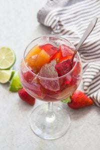Vegan Jello in a Wine Glass with Napkin and Fruit in the Background