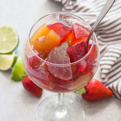 Vegan Jello in a Wine Glass with Napkin and Fruit in the Background