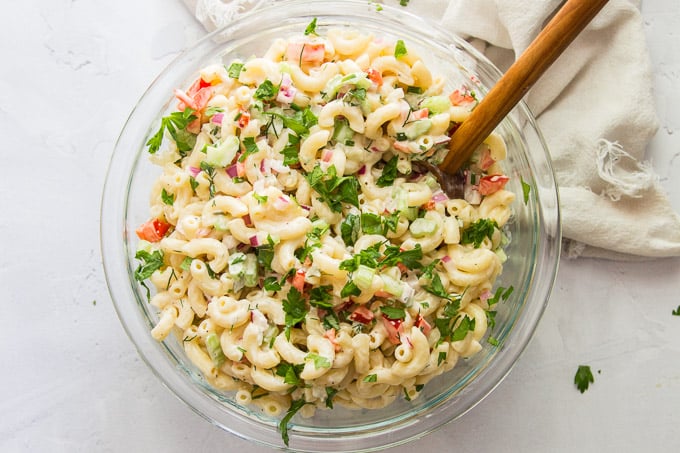 A Bowl of Vegan Macaroni Salad with Wooden Spoon
