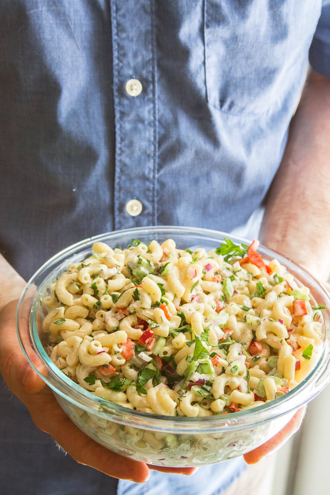 Hands Holding a Bowl of Vegan Macaroni Salad