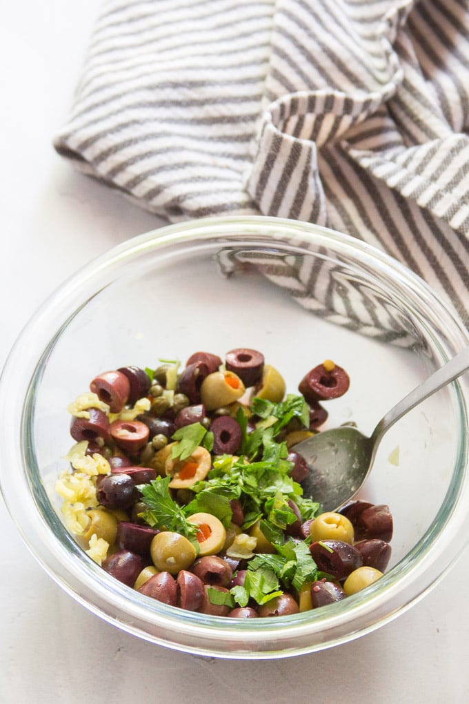 Bowl Filled with Olive Salad and a Spoon