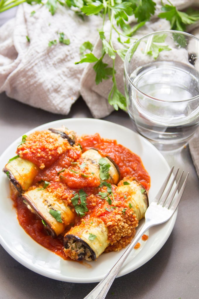 Vegan Eggplant Rollatini on a Plate with Water Glass and Napkin in the Background
