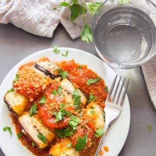Vegan Eggplant Rollatini on a Plate with Fork, Water, Glass and Napkin